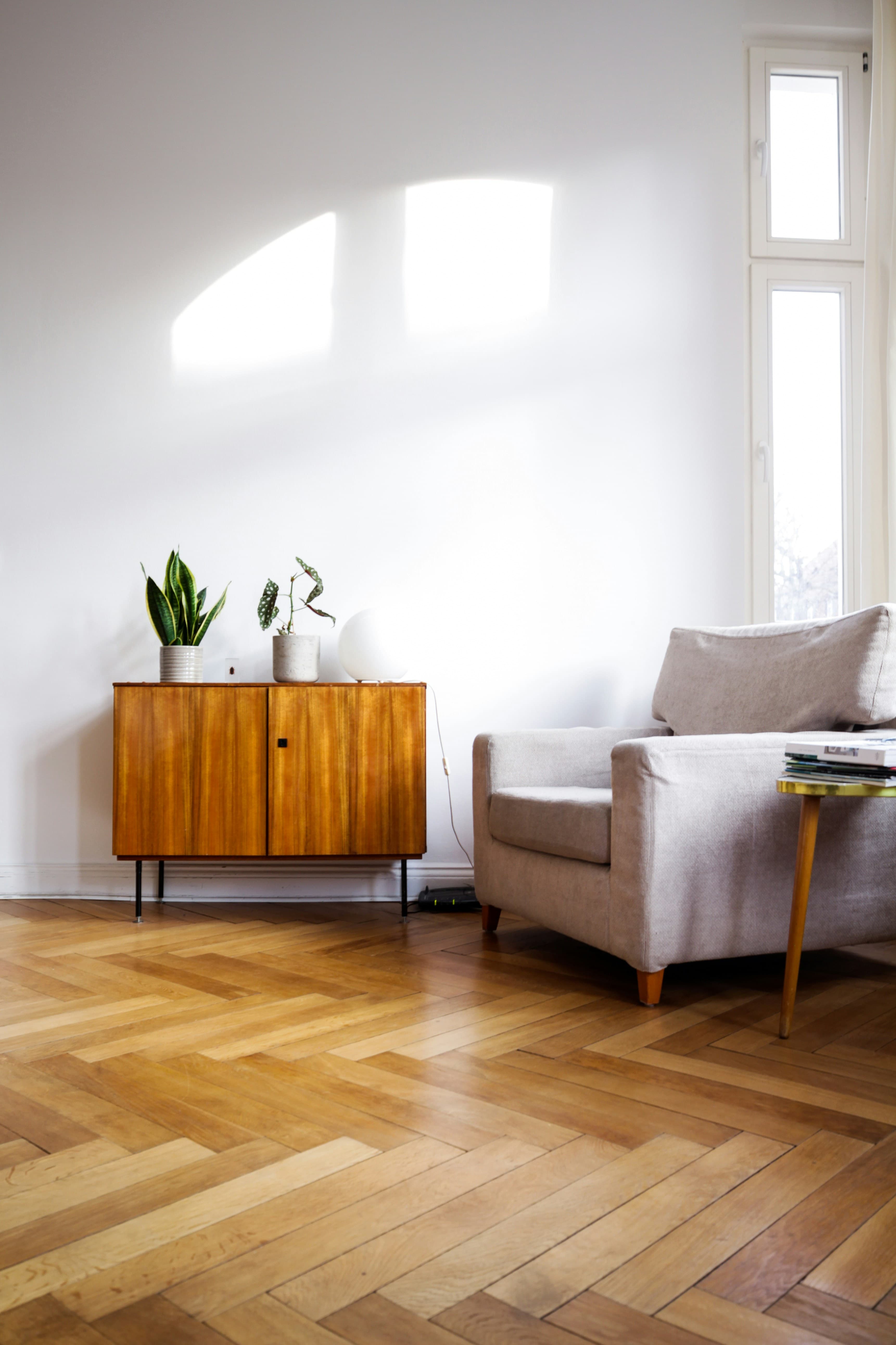 A bright living room with herringbone-pattern hardwood flooring